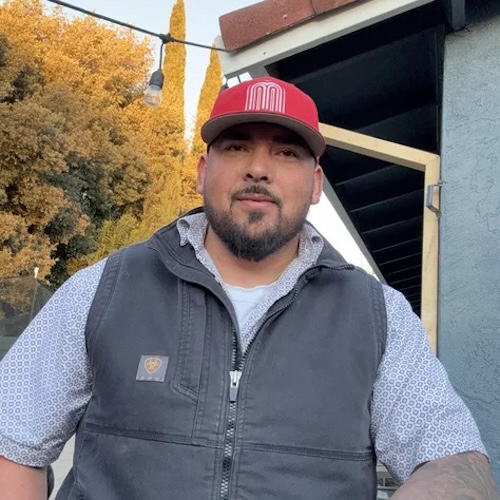 bacilio wearing hat and vest outside