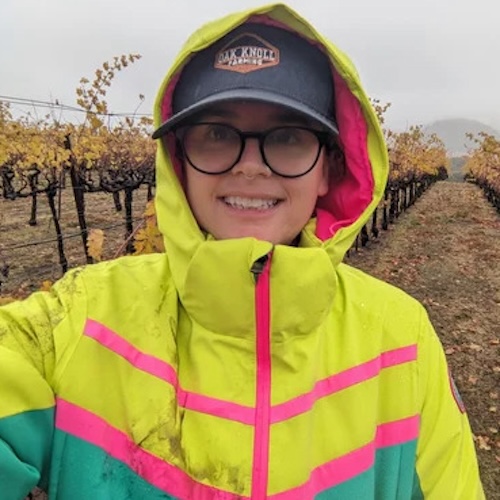 emilie in rain jacket on vineyard