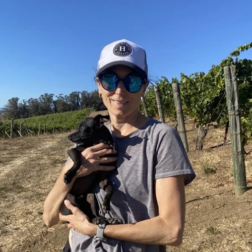 leslie holding dog on vineyard